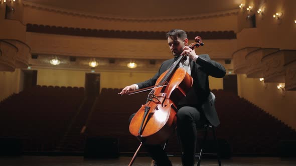 Talented Violoncellist is Rehearsing on Scene of Empty Old Opera House Portrait of Cellist in