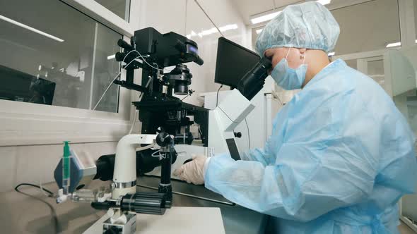 Coronavirus Epidemia, Virus Vaccine Concept. Female Expert Is Operating a Microscope in the Lab