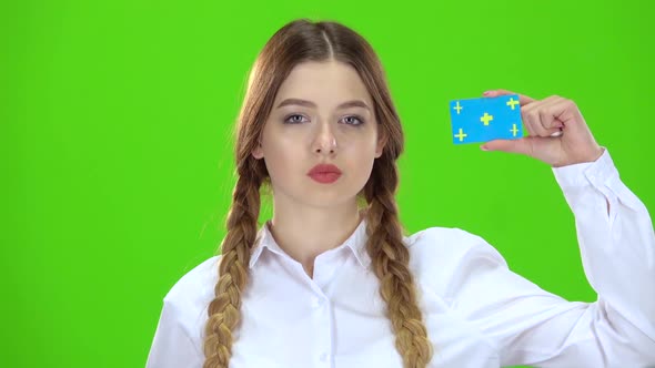 Teenage Girl Raises a Card and Points at It . Green Screen