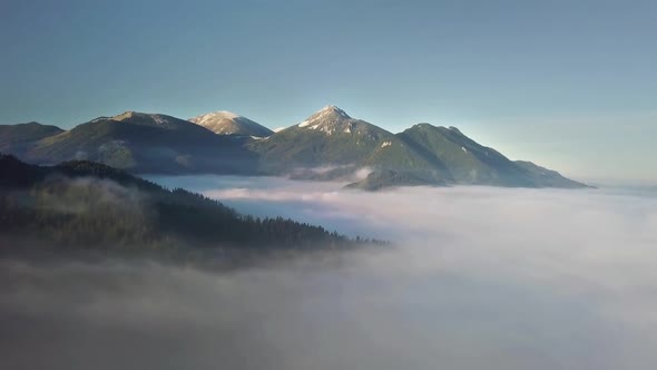 Fly Above Foggy Clouds in Sunny Mountains