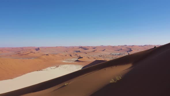 Aerial view of people walking on a sand dune crest in Namib Desert, Namibia.