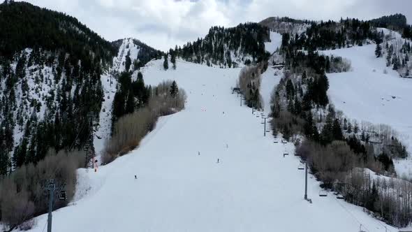 Ski resort slope with many people in aerial drone time lapse shot