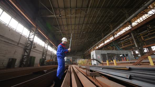 Worker in a White Helmet Bites the Steel Wire with Wire Cutters