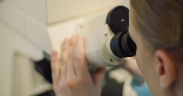 Scientist Examining Bacteria Under Microscope at Laboratory