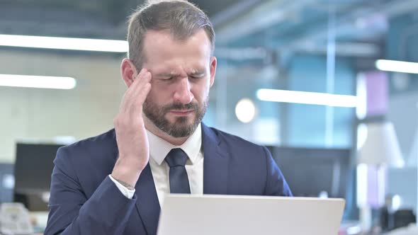 Portrait of Businessman Having Headache in Office