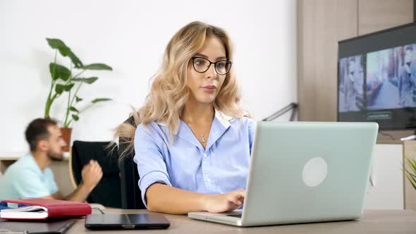 Freelancer Woman Working on the Laptop While Her Boyfriend Is Making a Lot of Noise 