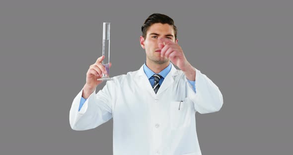 Doctor using digital screen while examining chemical in test tube