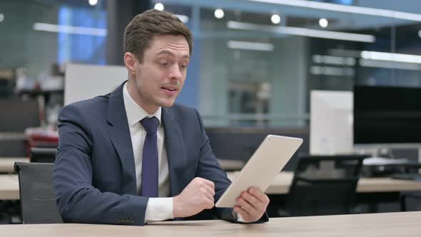 Businessman Making Video Call on Tablet in Office Sitting