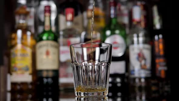 Closeup of a Bartender Pouring Whiskey Into a Glass in a Bar