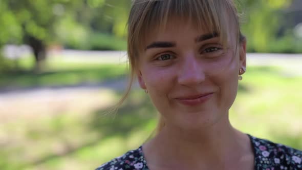 Happy Woman with Blonde Hair Smiling in the Park