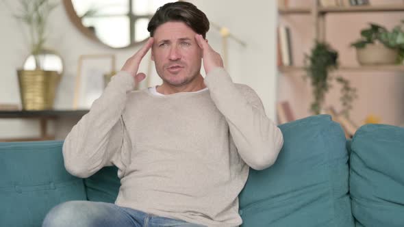 Stressed Middle Aged Man with Headache at Home