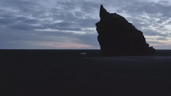 Aerial Scenic Shot and a Silhouette of Sea Stack with Cloudy Skies at Dawn