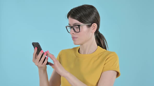 Serious Young Woman Surfing Internet on Phone on Purple Background 