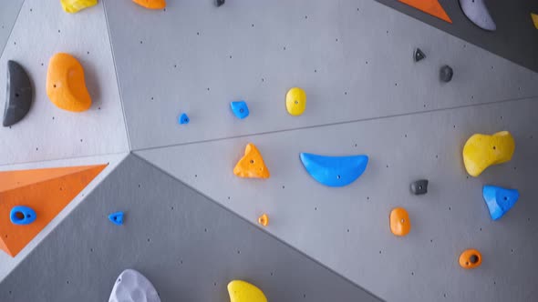 Indoor bouldering wall with colorful climbing holds. Gym indoor extreme training