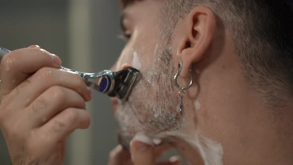Side View Closeup Man Shaving Cheek with Razor in Slow Motion