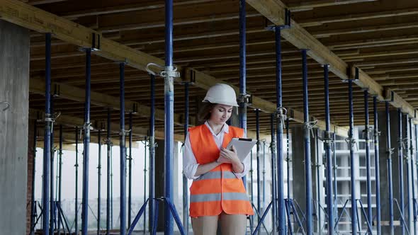 Engineer or Architect working at Construction Site. A woman with a tablet at a construction site