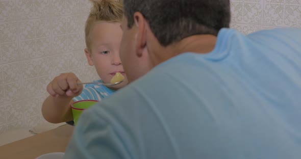 Child having dinner with father at home