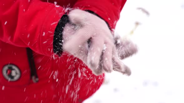 Close Up of Woman's Hands Shaking Off Snow of Gloves