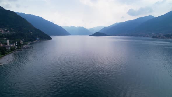 Aerial Flying Over Calm Waters Of Lake Como. Dolly Back, Establishing Shot