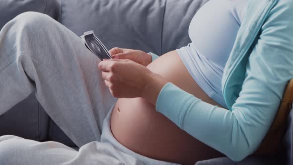 Young pregnant woman is resting at home and expecting a baby.