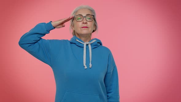 Mature Old Grandmother Giving Salute Listening to Order As If Soldier Following Discipline Obeying