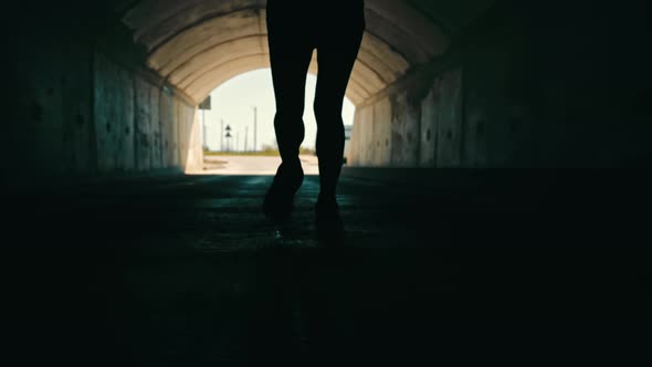 Woman Running in a Dark Tunnel to Meet the Light