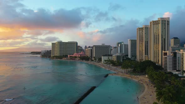 Aerial Drone View of Beachfront Resort Hotel Buildings And People Swimming On Kuhio Beach In Waikiki