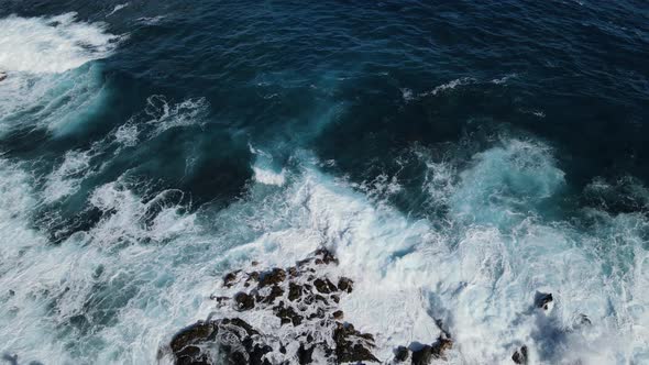 wave crashing against lava cliffs in hawaii