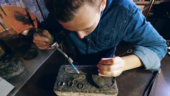 Jeweler Makes a Piece of Jewelry. Male Jeweler Is Heating a Silver Chain