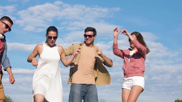 Happy Friends Dancing at Summer Party Outdoors 