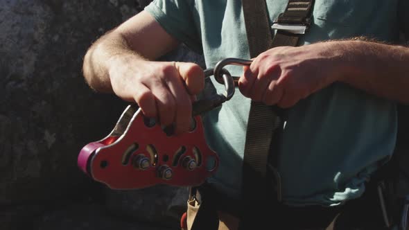 Young Caucasian man fastening zip lining harness