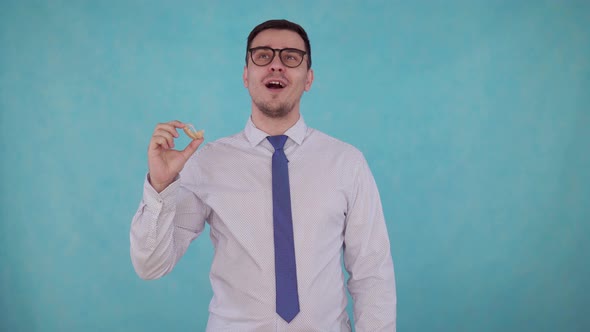 Man Removes the Hearing Aid From His Ear and Hears on Blue Background