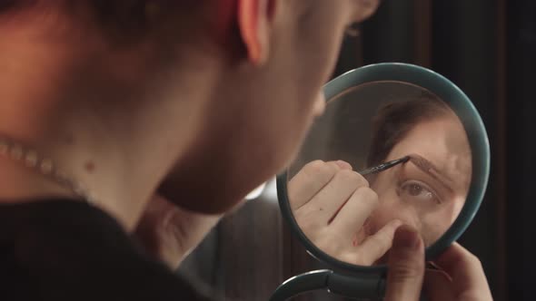 Drag Artist  Young Man Drawing New Eyebrows in Front of the Small Mirror