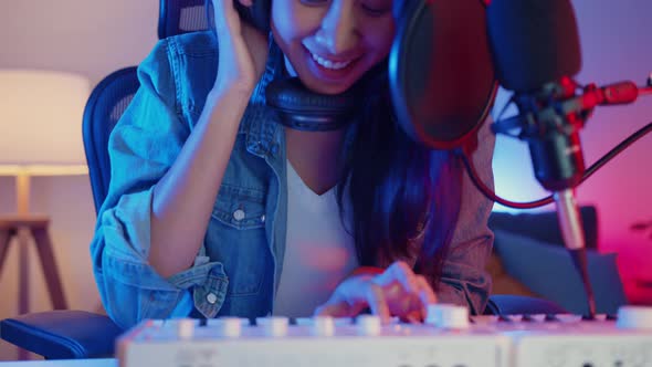 Happy asia girl blogger play synthesizer keyboard wear headphone and record music.