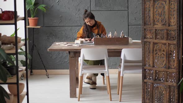 Professional Potter Woman Working on Details of a Clay Handcraft Piece in a Big Studio