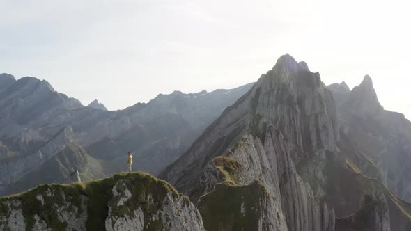 Aerial flies around a person and shows the beautiful Mountains of Schäfler, Appenzell, Switzerland