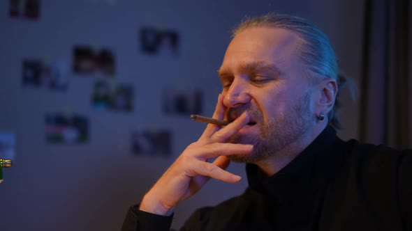 Thoughtful Handsome Police Detective Smoking Cigarette Investigating Case at Night Indoors