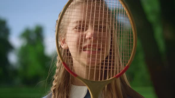 Cute Smiling Girl Look Camera Through Racket Net Closeup