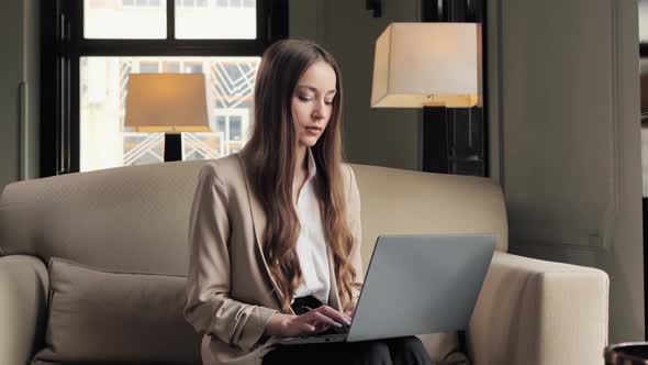 Portrait of Serious Businesswoman Working on Laptop in Hotel Restaurant