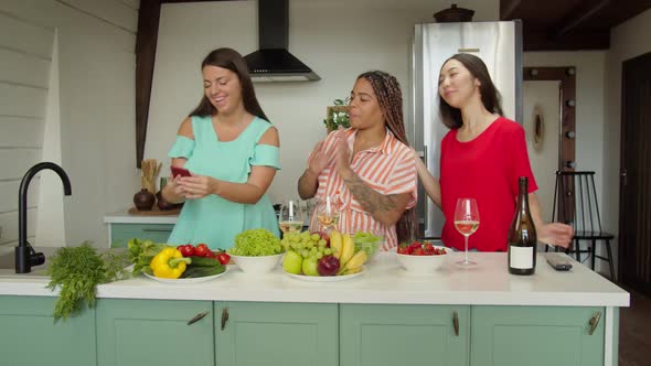 Three Interethnic Female Friends Taking Selfies on Phone in Kitchen