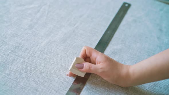 Seamstress Makes Marks on Linen Fabric with Chalk and Ruler