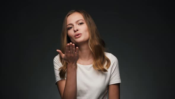 Portrait of Young Beautiful Caucasian Woman Blowing a Kiss and Smiling