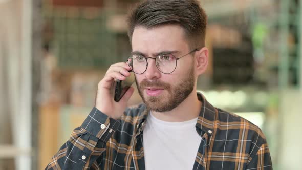 Portrait of Angry Young Man Arguing on Smartphone