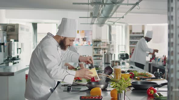 Male Chef Grating Parmesan Cheese on Plate to Cook Italian Dish