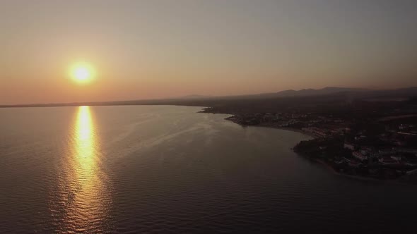 Sea and Coastal Town at Sunset, Aerial. Distant View of Trikorfo Beach, Greece