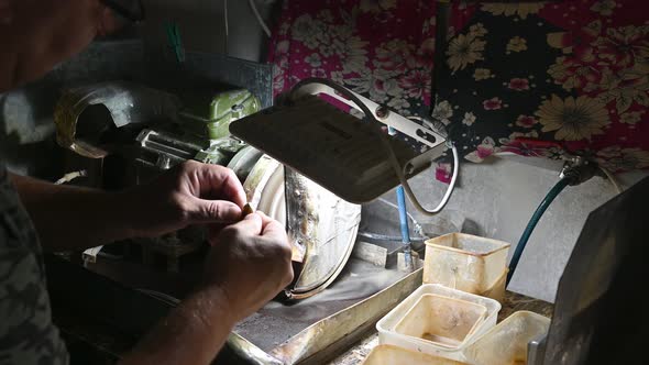 Master Grinding Amber on Machine for Making Jewelry