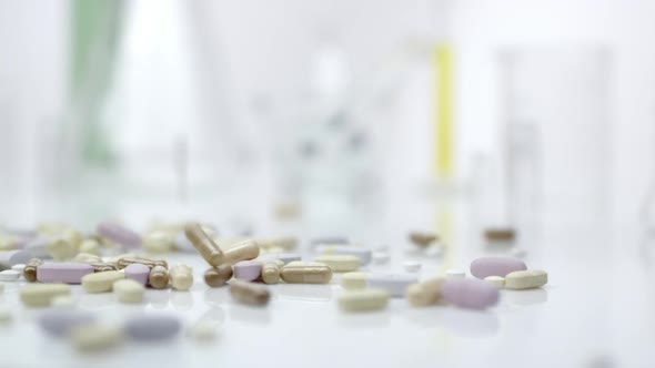 Panning view of pills dropping