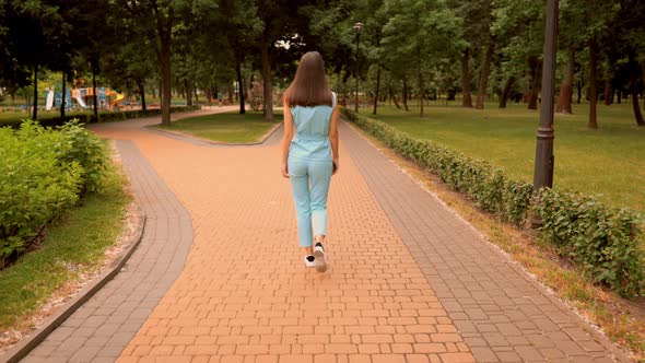 Back View Cheerful Caucasian Woman Walking Have Fun on the Street in City Park