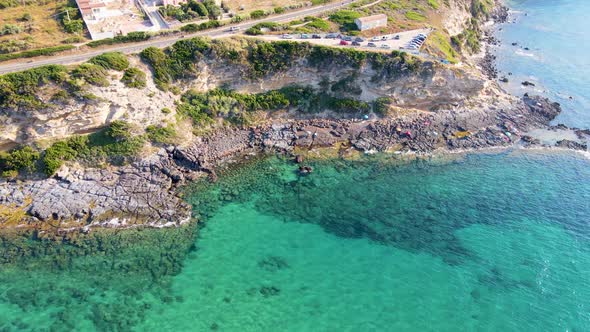 Descendant aerial drone view of coastline with people sunbathing and relaxing