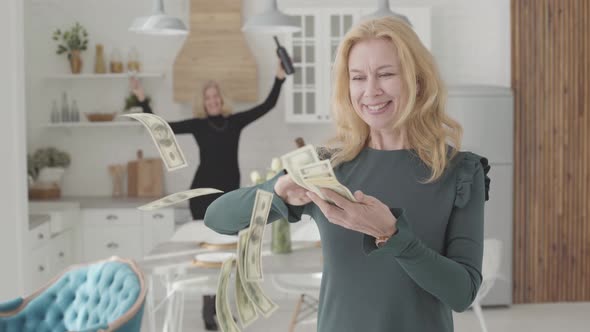 Rich Mature Caucasian Woman Scaterring Money and Smiling